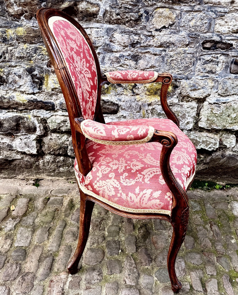 A French Louis XV style open-arm chair crafted from carved walnut with red and gold damask upholstery. View VII