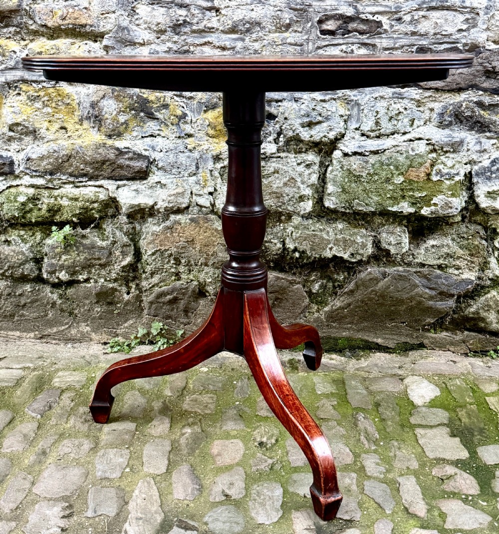 A Regency mahogany tripod side table featuring a rounded rectangular top supported by a turned central pedestal and three splayed legs. View II