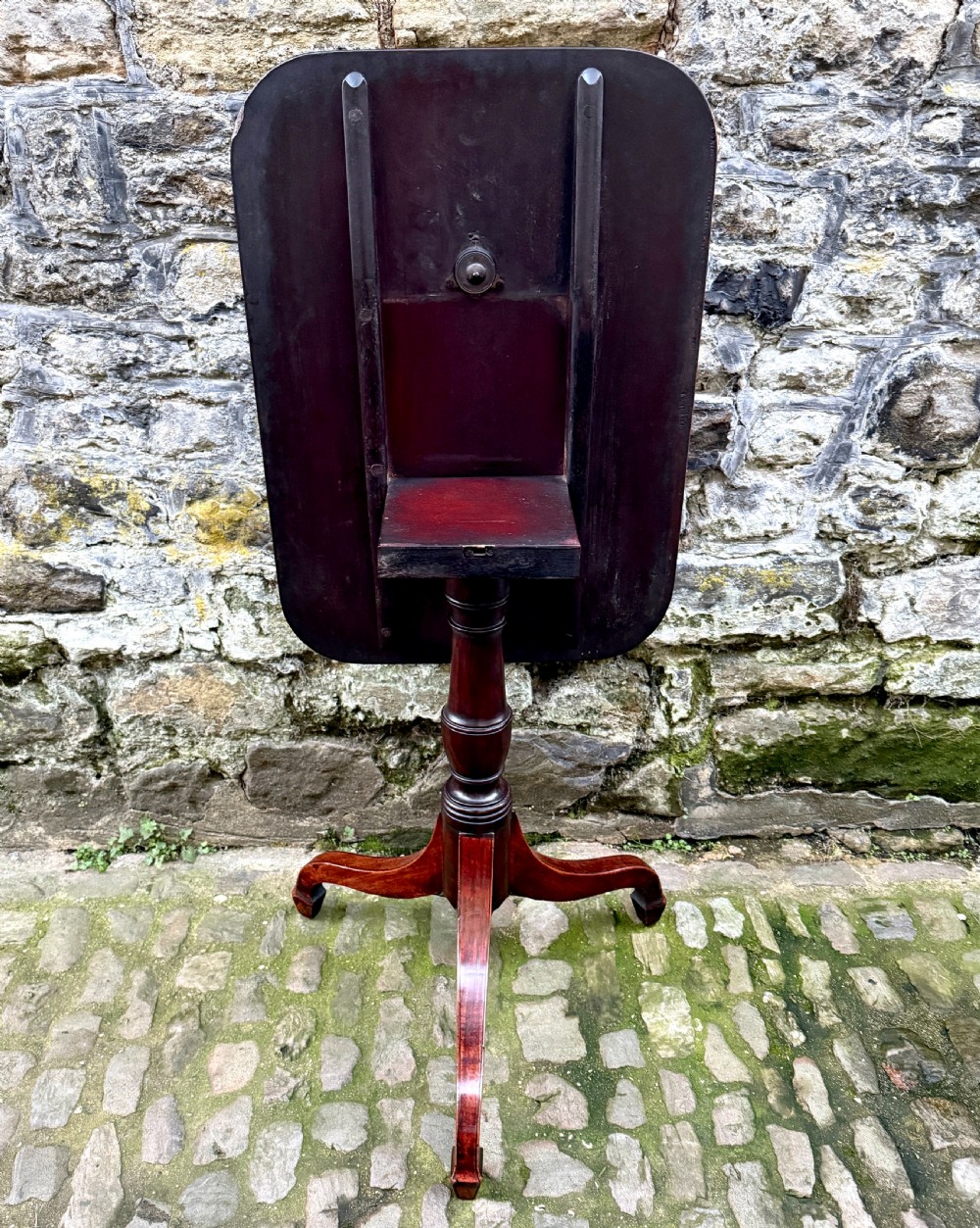 A Regency mahogany tripod side table featuring a rounded rectangular top supported by a turned central pedestal and three splayed legs. View V