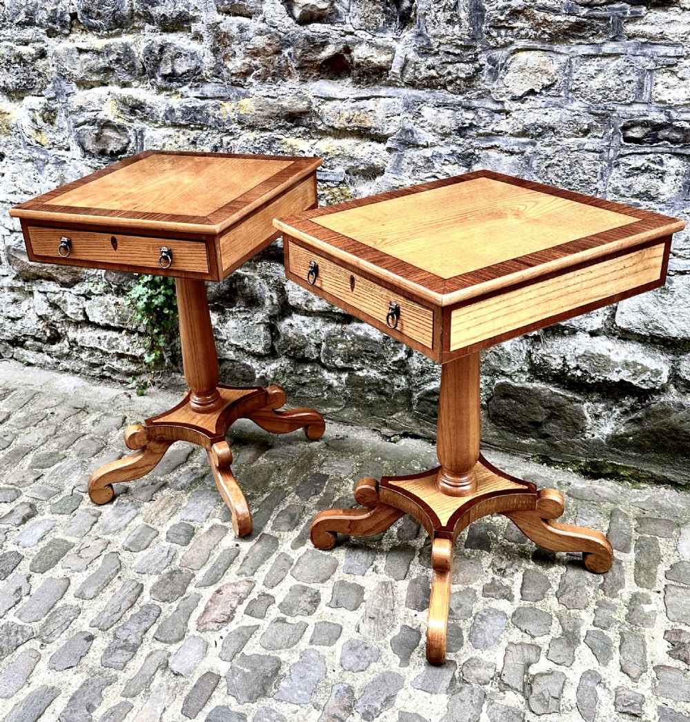 A pair of early 20th century ash pedestal side tables featuring single drawers with brass lion mask ring handles and quadruped scrolled bases. View V