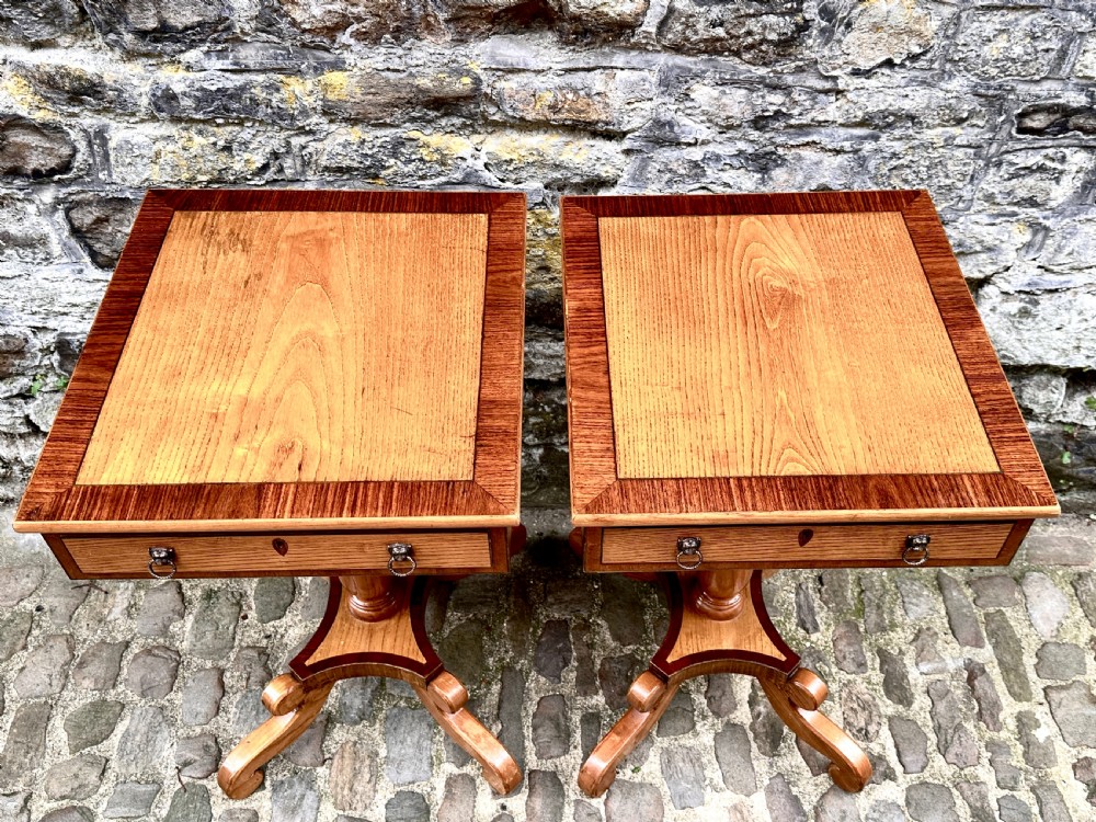 A pair of early 20th century ash pedestal side tables featuring single drawers with brass lion mask ring handles and quadruped scrolled bases. View VI