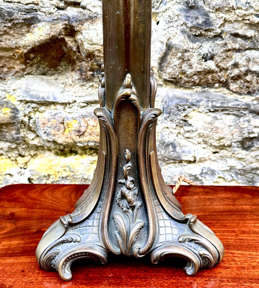 A French Art Nouveau cast bronze table lamp base featuring sweeping organic foliate motifs and a fluted central column. View V