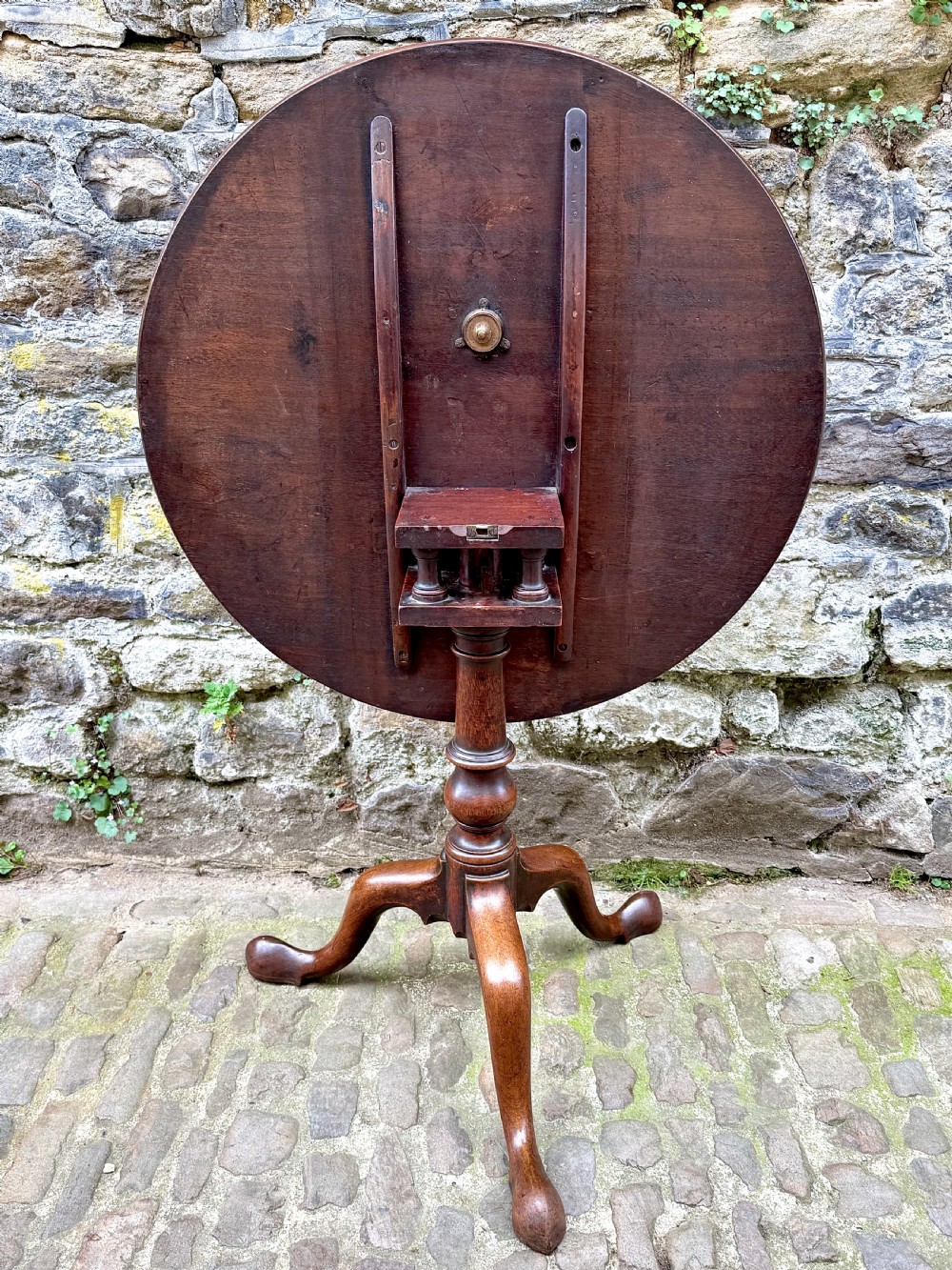 An 18th-century George III mahogany tripod table with a circular tilt top surface, turned column pedestal, and three cabriole legs. View III