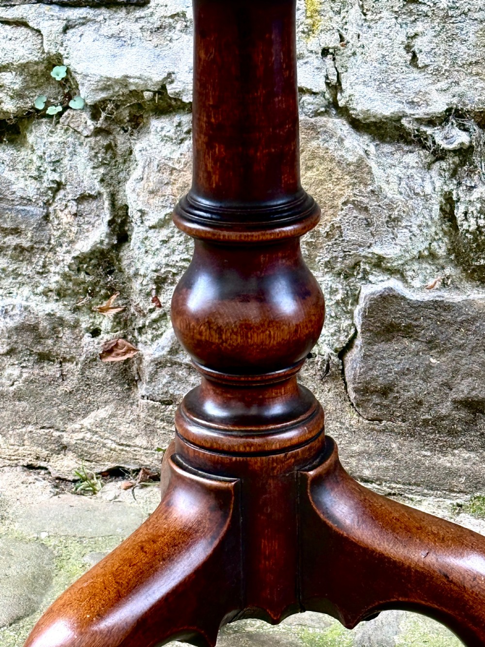 An 18th-century George III mahogany tripod table with a circular tilt top surface, turned column pedestal, and three cabriole legs. View VII