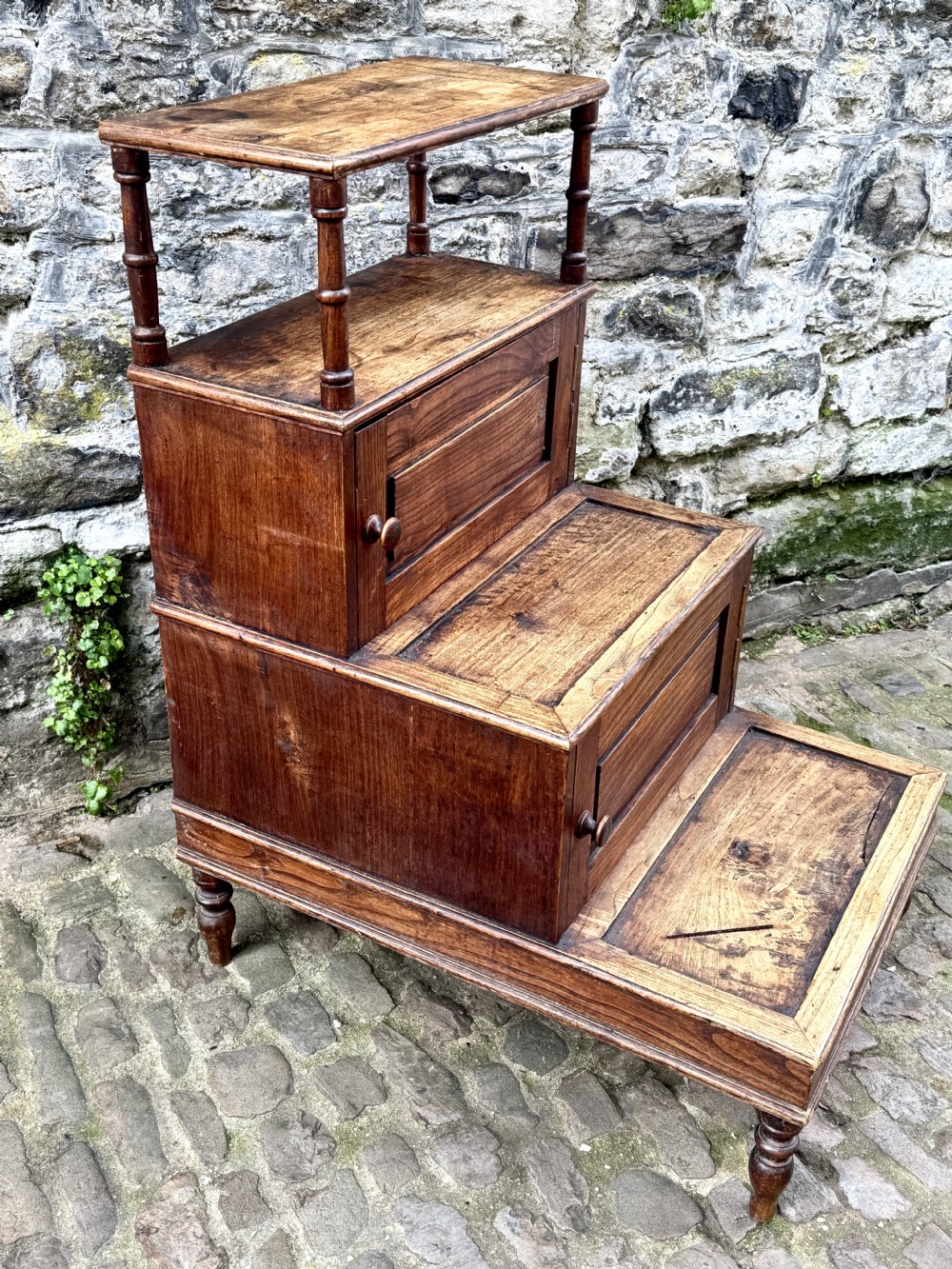 A flight of late Victorian oak library steps featuring three tiers, built-in cupboard doors, and turned support legs. View III