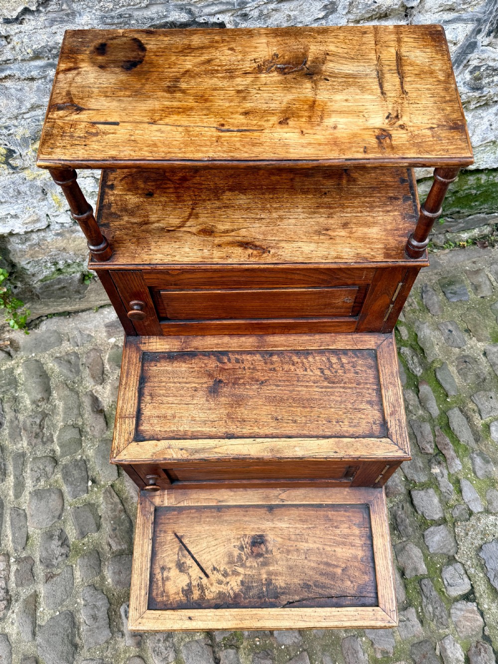 A flight of late Victorian oak library steps featuring three tiers, built-in cupboard doors, and turned support legs. View IX