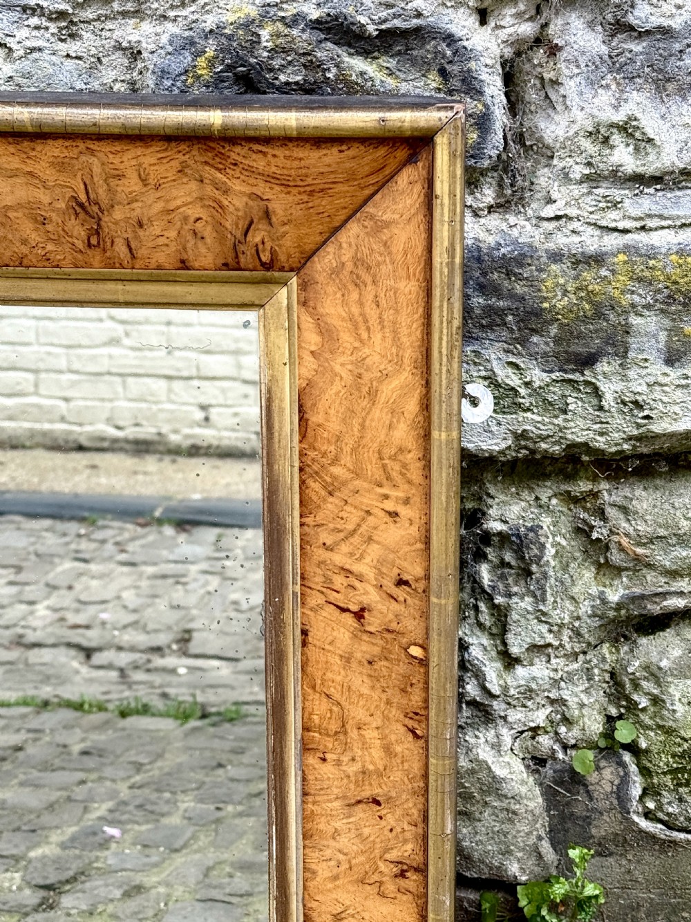 A rectangular early 19th-century Regency overmantel mirror framed in figured burl wood veneer with an inner gilt slip border and corner plinth feet. View III