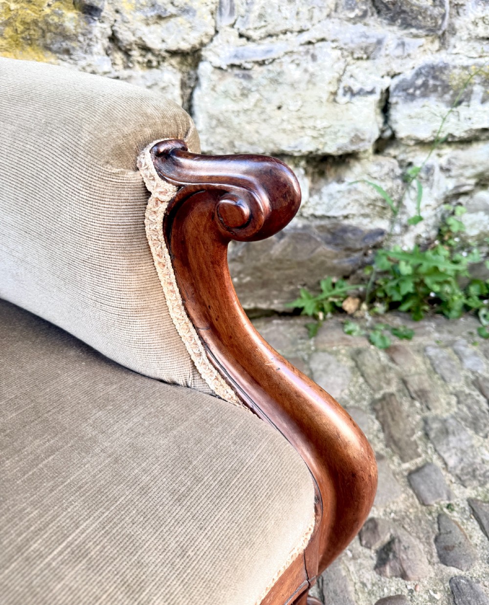 An Early Victorian walnut armchair featuring deep button-tufted olive green velvet upholstery, carved padded armrests, and cabriole front legs. View VII