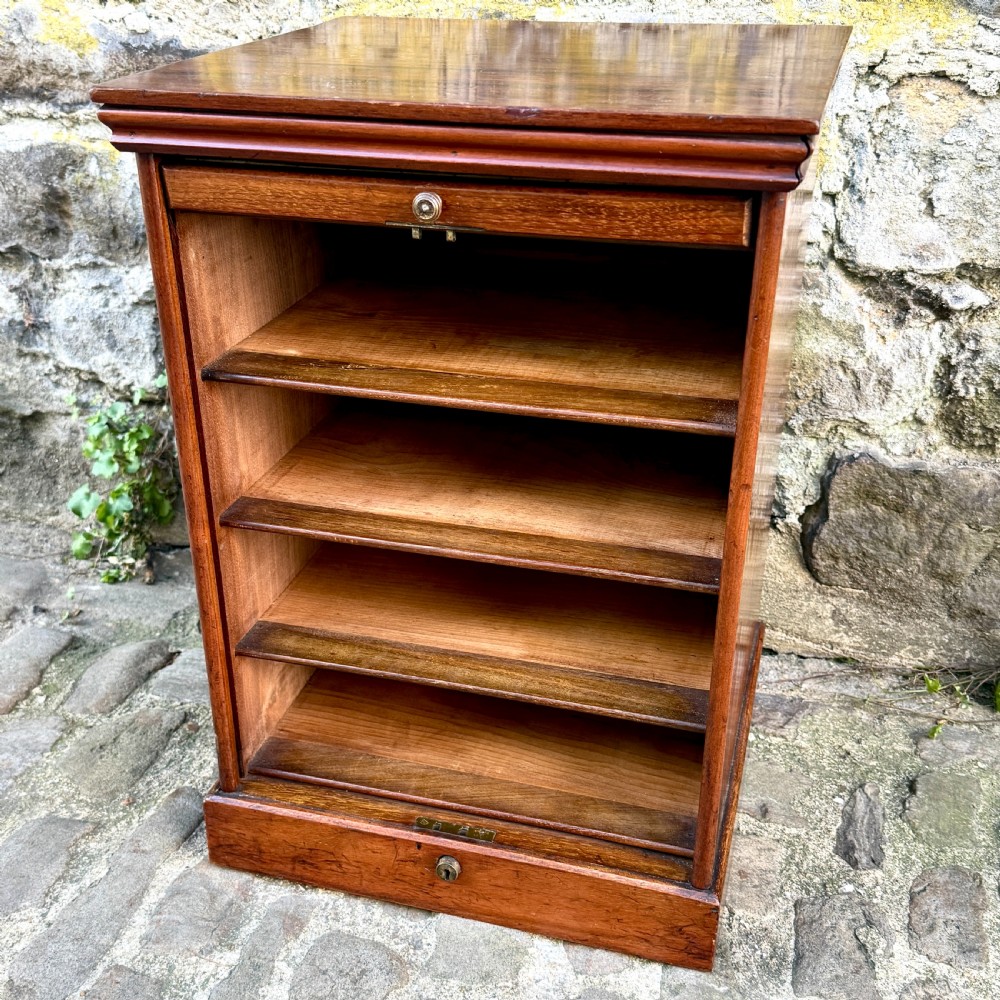 A late 19th-century rosewood filing cabinet featuring a slatted tambour shutter front and a lower drawer with brass keyhole escutcheons. View IV