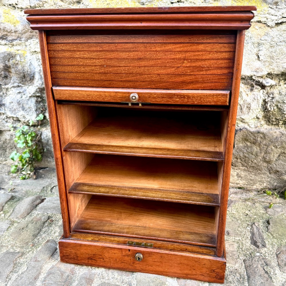 A late 19th-century rosewood filing cabinet featuring a slatted tambour shutter front and a lower drawer with brass keyhole escutcheons. View V