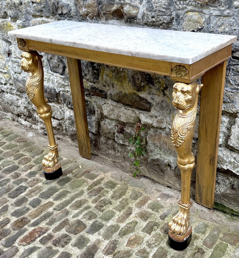 A Regency giltwood console table featuring a grey marble top supported by two carved lion monopodia front legs. View III