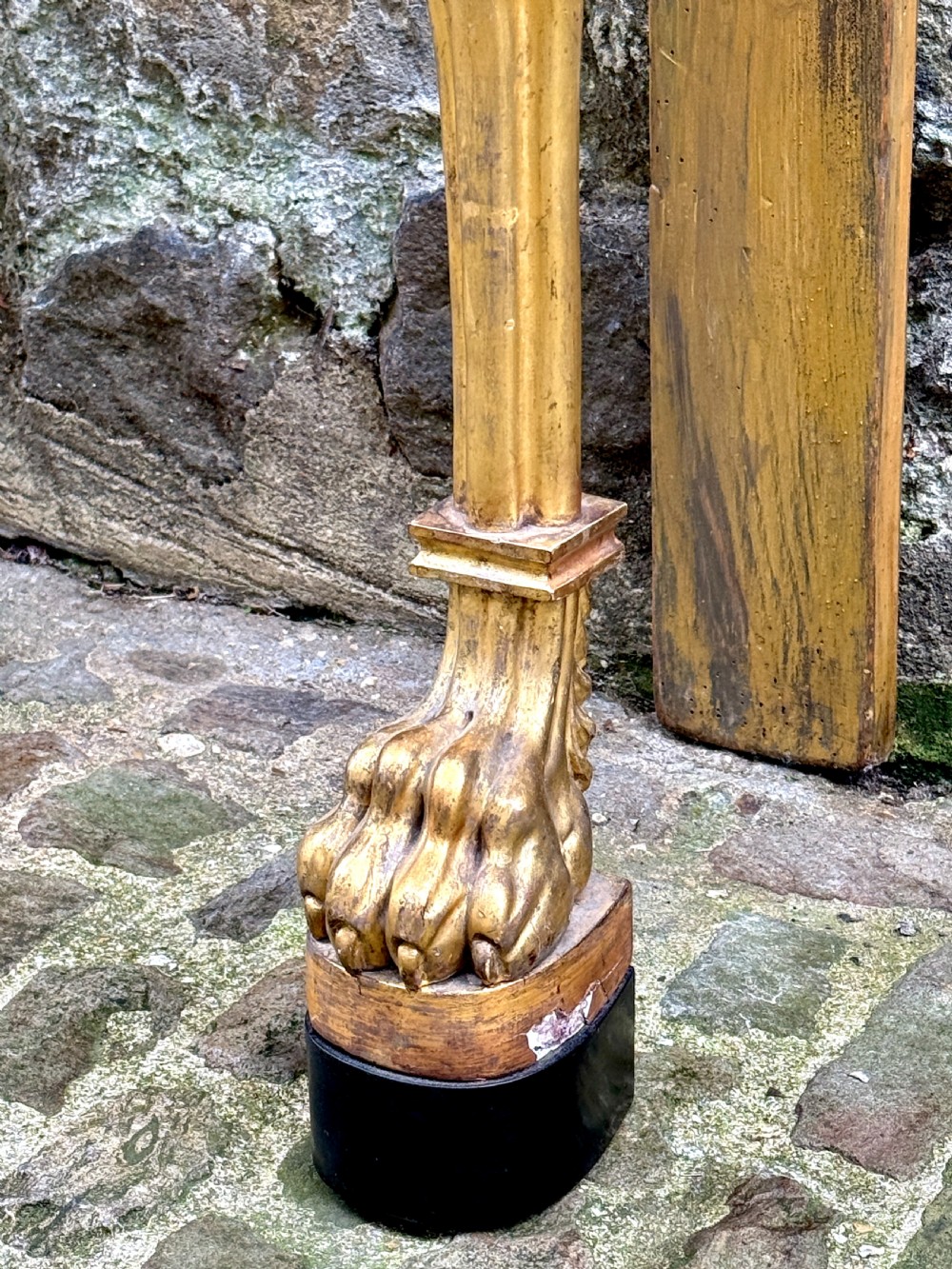 A Regency giltwood console table featuring a grey marble top supported by two carved lion monopodia front legs. View V