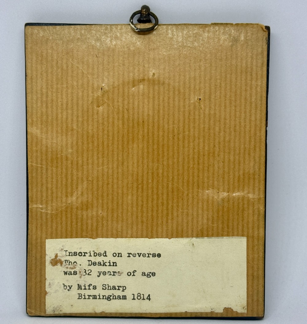 A Regency profile portrait miniature of a gentleman in a white cravat, set within an oval gilt bezel and rectangular black ebonised frame. View III