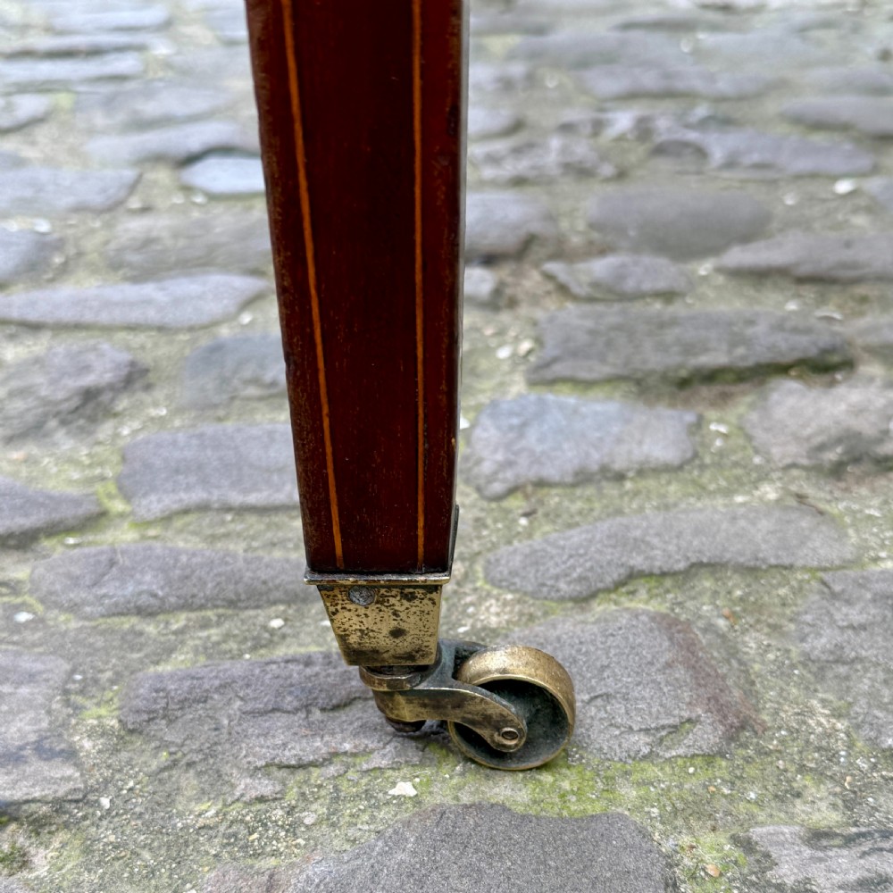 A George III mahogany Pembroke table with satinwood inlay, tapered square legs, and brass castors. View IX