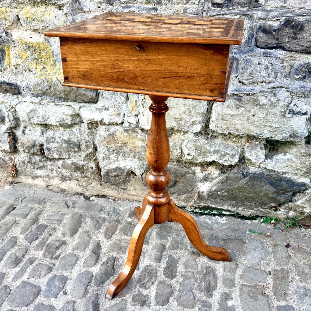 An early nineteenth-century French Provincial wooden chess table featuring an inlaid chessboard top, a turned pedestal support, and a tripod cabriole base. View II