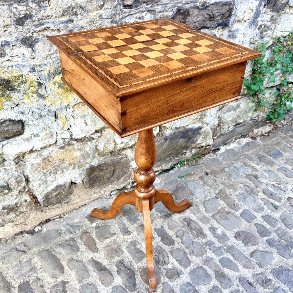 An early nineteenth-century French Provincial wooden chess table featuring an inlaid chessboard top, a turned pedestal support, and a tripod cabriole base. View V