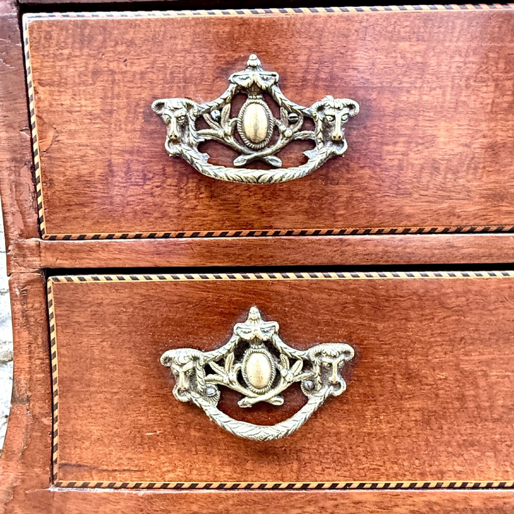 A late 18th-century Dutch mahogany chest of drawers featuring a shaped bombee profile, four long drawers with decorative brass handles, and bracket feet. View IX