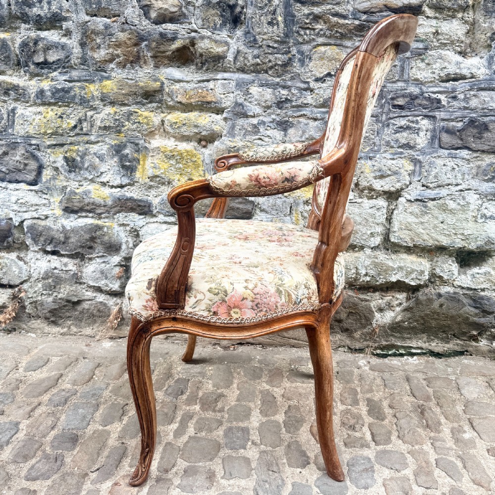 A Louis XV French provincial wooden armchair with carved cabriole legs and floral tapestry upholstery across the seat, backrest, and armrests. View IV