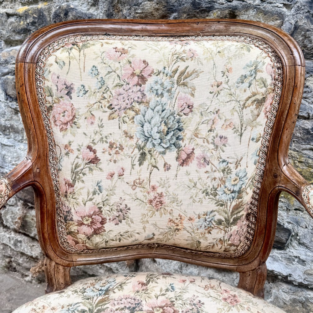 A Louis XV French provincial wooden armchair with carved cabriole legs and floral tapestry upholstery across the seat, backrest, and armrests. View VII