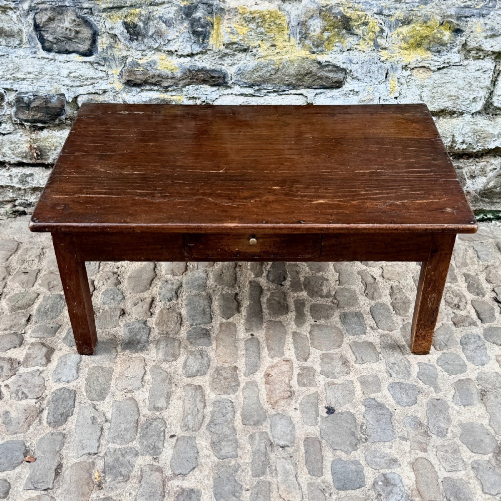 A low rectangular antique coffee table constructed from dark oak and chestnut, featuring a single frieze drawer and four straight square legs.
