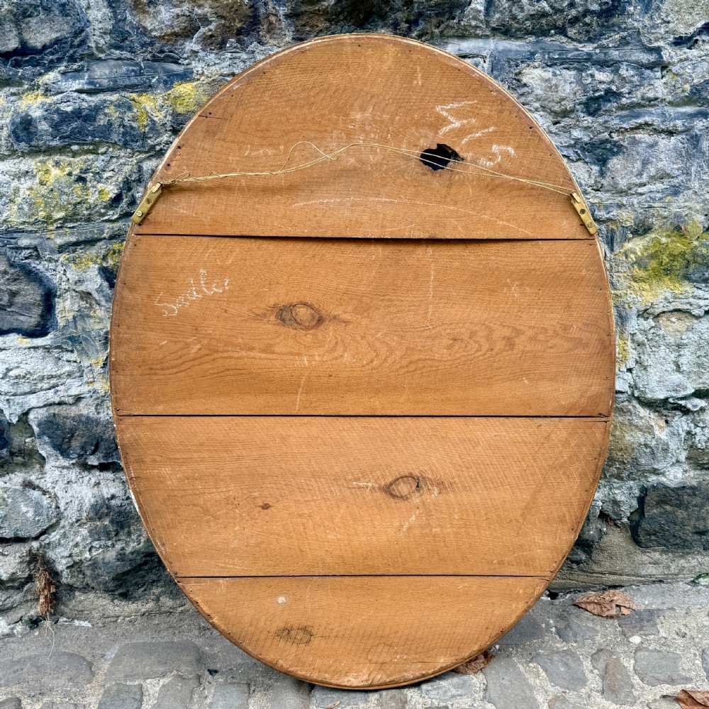 An oval giltwood wall mirror featuring a double-ring frame connected by small decorative spacers and decorated with beaded moulding. View IV