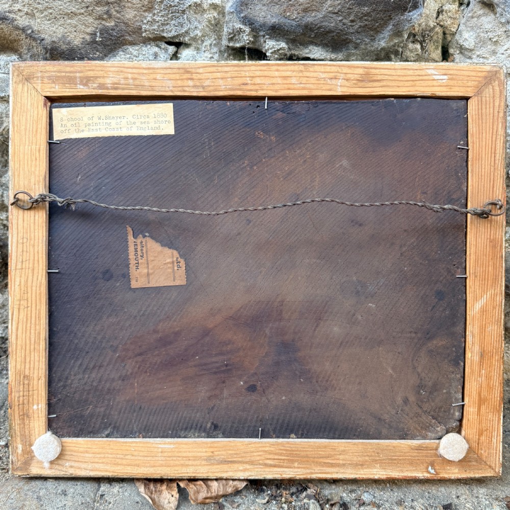 A nineteenth-century coastal oil painting depicting figures and fishing boats on a sandy shore under a cloudy sky, presented in a moulded gold frame. View IV
