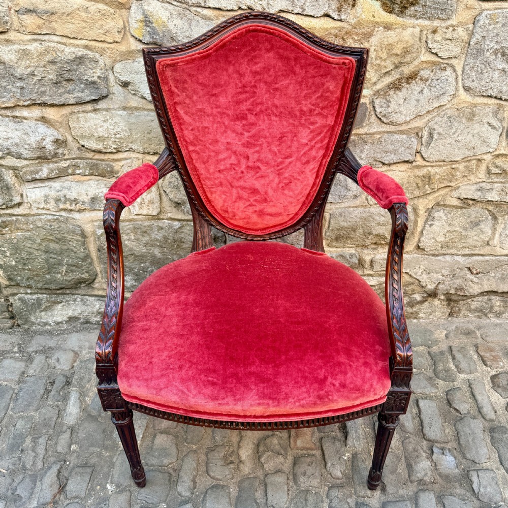 A Sheraton Revival mahogany desk chair with red velvet upholstery, a shield back, and fluted front legs. View III