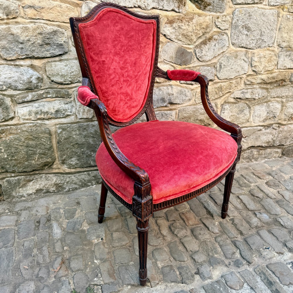 A Sheraton Revival mahogany desk chair with red velvet upholstery, a shield back, and fluted front legs. View IV