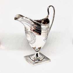A GEORGE III SILVER HELMET CREAM JUG