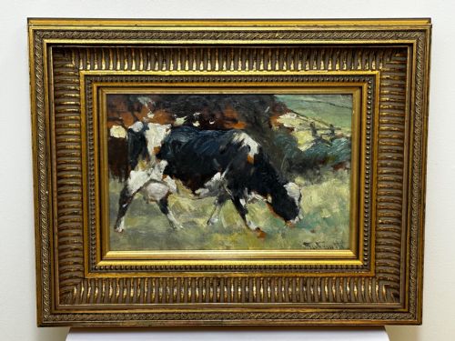 fig 1. An impressionist oil painting depicting a black and white Friesian cow grazing in a field, set within a heavily moulded gilt frame.