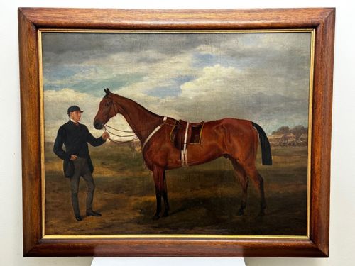 fig 1. A 19th-century British oil painting depicting a saddled bay hunter horse and groom standing in a landscape, set within a timber frame.