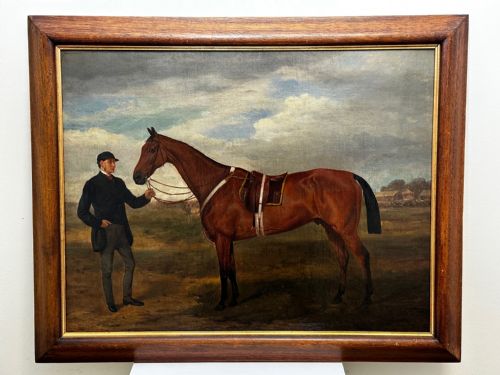 fig 2. A 19th-century British oil painting depicting a saddled bay hunter horse and groom standing in a landscape, set within a timber frame.