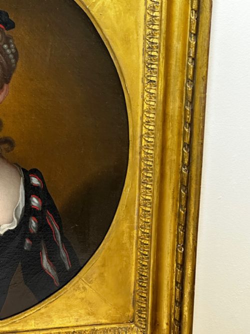 fig 3. An 18th-century oil portrait of a lady in a black bodice and feathered headpiece within an oval spandrel inside a square gilded frame.