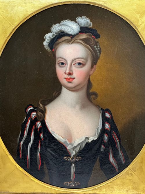 fig 4. An 18th-century oil portrait of a lady in a black bodice and feathered headpiece within an oval spandrel inside a square gilded frame.