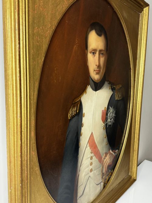 fig 1. A 19th-century French oil painting depicting Napoleon Bonaparte in military uniform with epaulettes, set within an oval spandrel inside a rectangular gilded wood frame.