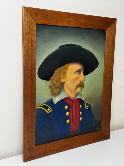 fig 3. A framed oil painting portraying General George Custer in profile wearing a blue uniform with gold stars and a black hat.