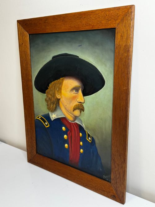 fig 5. A framed oil painting portraying General George Custer in profile wearing a blue uniform with gold stars and a black hat.