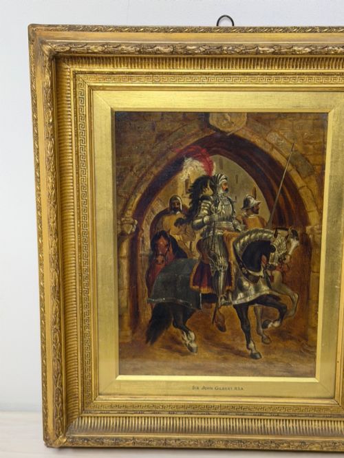 fig 2. An antique oil painting depicting a knight in full armour riding a horse beneath a stone archway, framed in an ornate gilded wood frame.