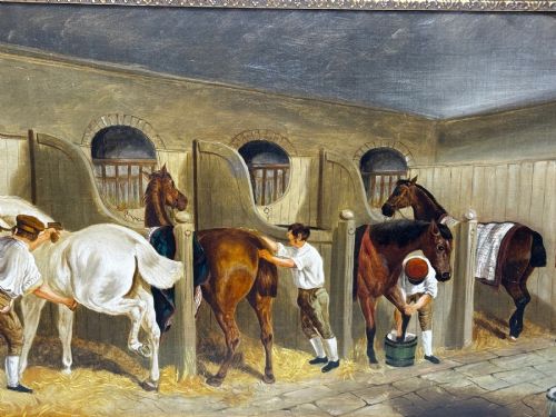 fig 5. A horizontal oil painting depicting grooms tending to horses inside a stable block, housed within a fluted gilt wood frame.