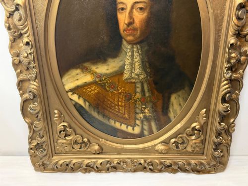 fig 1. An 18th-century oil painting depicting King William III in a curled wig and ermine cloak, set within an oval aperture inside an ornate rectangular gold carved frame.