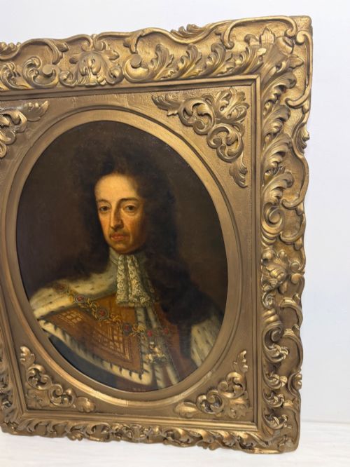 fig 2. An 18th-century oil painting depicting King William III in a curled wig and ermine cloak, set within an oval aperture inside an ornate rectangular gold carved frame.