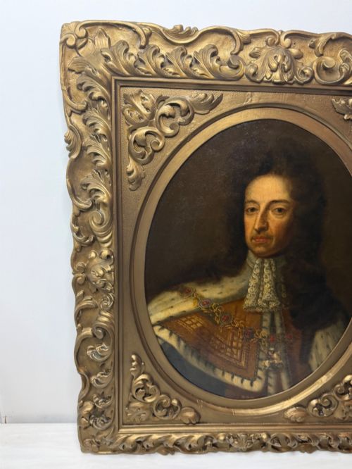 fig 3. An 18th-century oil painting depicting King William III in a curled wig and ermine cloak, set within an oval aperture inside an ornate rectangular gold carved frame.