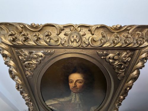 fig 4. An 18th-century oil painting depicting King William III in a curled wig and ermine cloak, set within an oval aperture inside an ornate rectangular gold carved frame.