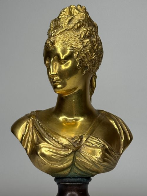 fig 4. A 19th-century gilt bronze bust portrait of Diana de Poitiers featuring an ornate hairstyle and classical drapery, mounted on a dark socle and square variegated marble base.