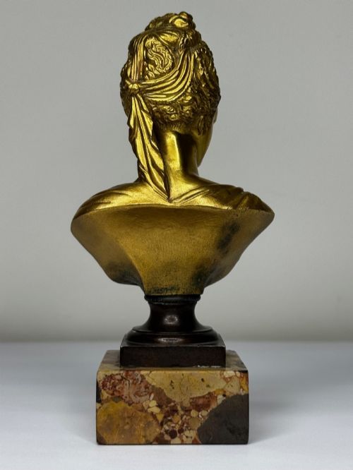 fig 5. A 19th-century gilt bronze bust portrait of Diana de Poitiers featuring an ornate hairstyle and classical drapery, mounted on a dark socle and square variegated marble base.