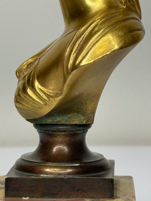 fig 8. A 19th-century gilt bronze bust portrait of Diana de Poitiers featuring an ornate hairstyle and classical drapery, mounted on a dark socle and square variegated marble base.