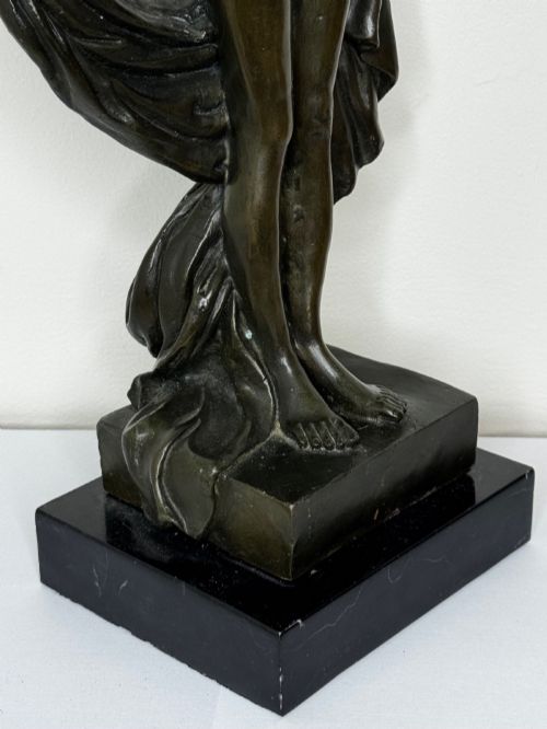 fig 1. A dark brown patinated French bronze sculpture depicting a standing female nude draped in flowing fabric, mounted on a dark marble base.