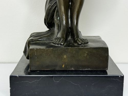 fig 2. A dark brown patinated French bronze sculpture depicting a standing female nude draped in flowing fabric, mounted on a dark marble base.