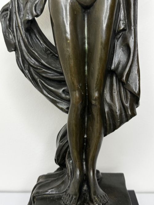 fig 4. A dark brown patinated French bronze sculpture depicting a standing female nude draped in flowing fabric, mounted on a dark marble base.
