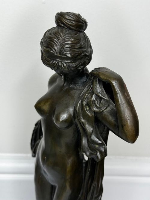 fig 6. A dark brown patinated French bronze sculpture depicting a standing female nude draped in flowing fabric, mounted on a dark marble base.